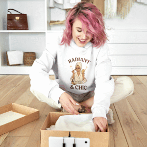 PerfectnElite Radiant & Chic hoodie for women featuring a woman in a robe applying makeup, cozy self-care sweatshirt, beauty and lifestyle apparel.