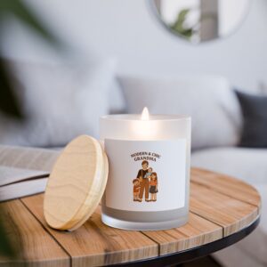 White candle with wooden lid featuring “Modern & Chic Grandma” illustration, lit on a wooden coffee table in a cozy living room.